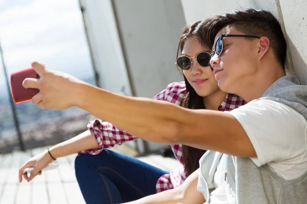 Щаслива молода пара використовує мобільний телефон у місті . — стокове фото