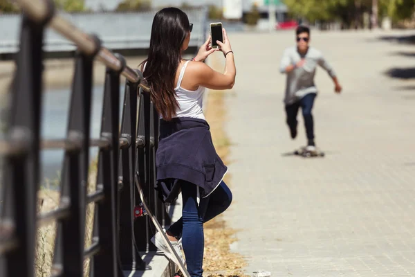 Два фигуриста с помощью мобильного телефона на улице . — стоковое фото