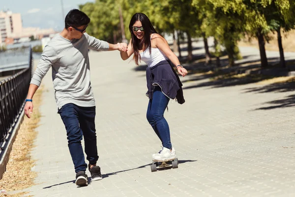 Młoda para skateboardingu na ulicy. — Zdjęcie stockowe