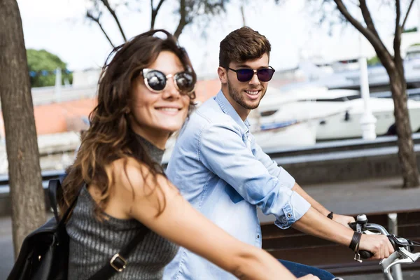 Feliz joven pareja ciclismo en la ciudad . — Foto de Stock