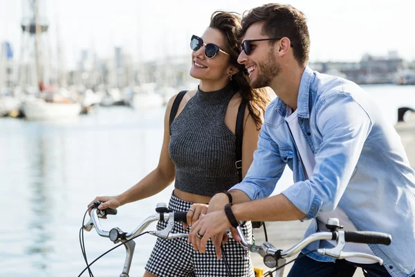 Feliz joven pareja ciclismo en la ciudad . —  Fotos de Stock