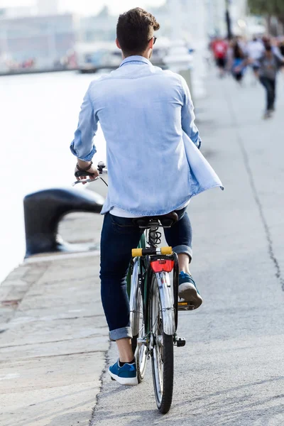 Beau jeune homme à vélo dans la ville . — Photo