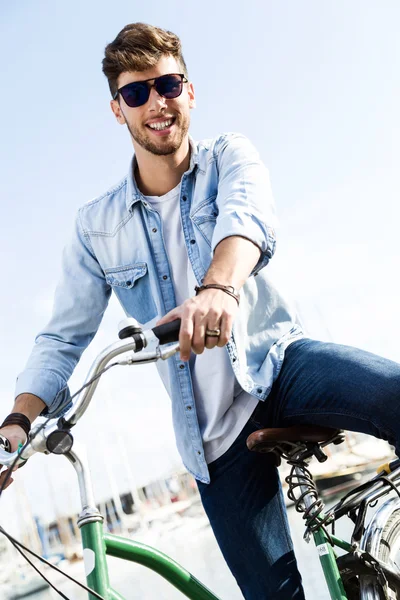 Knappe jongeman fietsen in de stad. — Stockfoto