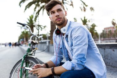 Yakışıklı genç adam sokakta cep telefonunu kullanma.