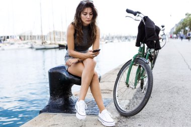 Sokakta cep telefonu kullanan güzel genç kadın.