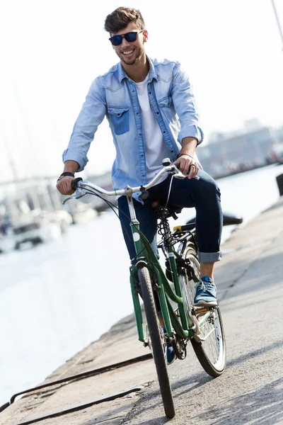 Beau jeune homme à vélo dans la ville . — Photo