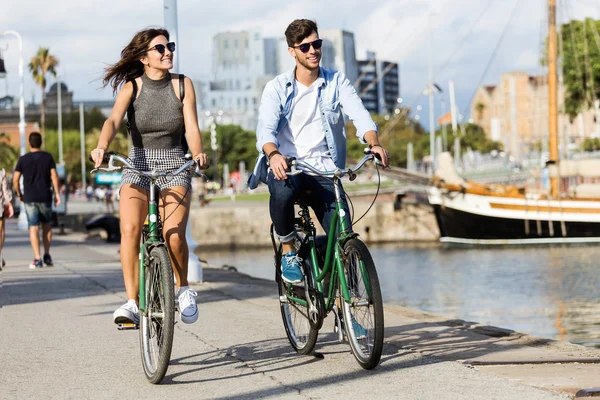 Gelukkige jonge paar fietsen in de stad. — Stockfoto