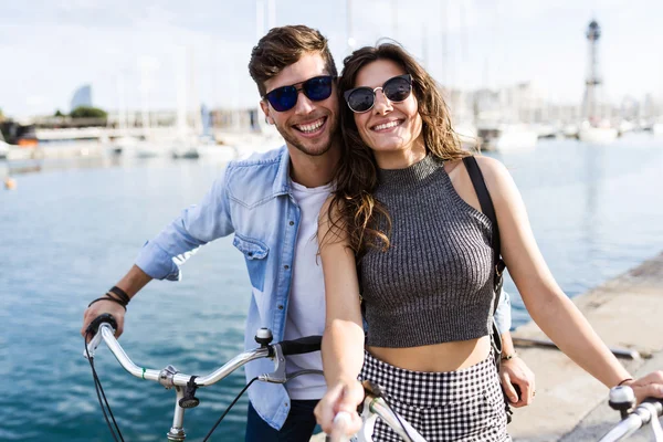 Feliz jovem casal de ciclismo na cidade . — Fotografia de Stock