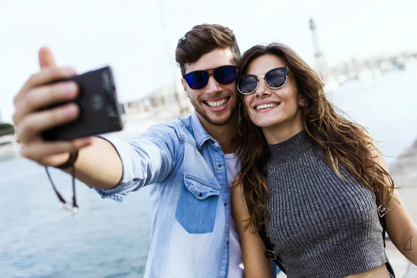Счастливая молодая пара с помощью мобильного телефона на улице . — стоковое фото