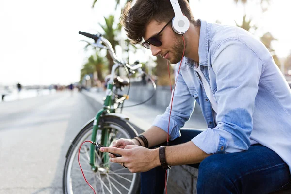 Joven guapo escuchando música en la calle . — Foto de Stock