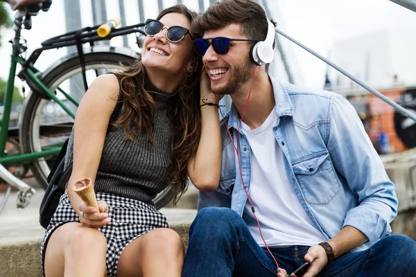 Feliz joven pareja escuchando música en la calle . — Foto de Stock