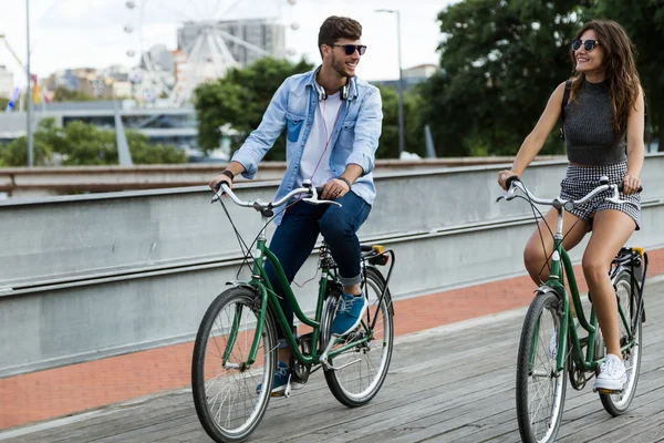 Feliz joven pareja ciclismo en la ciudad . —  Fotos de Stock