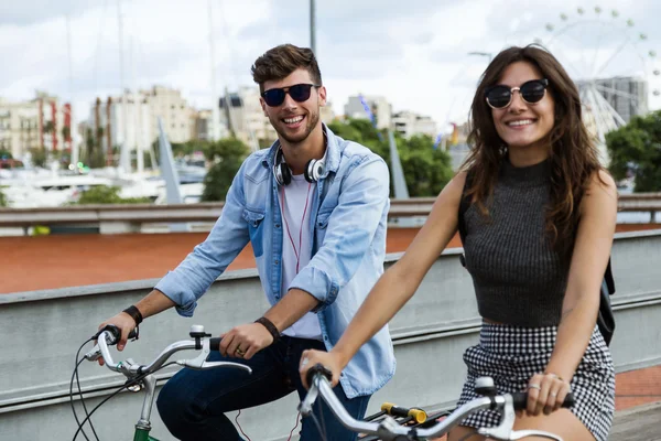 Glückliches junges Paar radelt in der Stadt. — Stockfoto