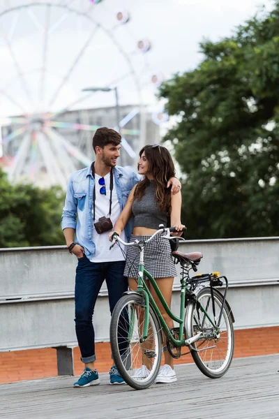 Feliz joven pareja ciclismo en la ciudad . — Foto de Stock