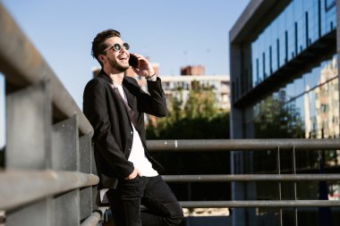 Yakışıklı genç adam sokakta cep telefonunu kullanma.