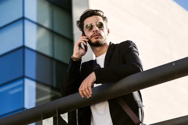 Handsome young man using his mobile phone in the street. — Stock Photo, Image