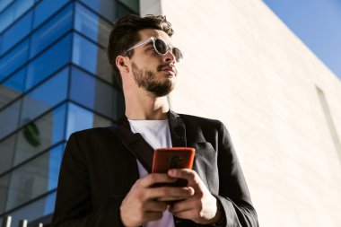 Yakışıklı genç adam sokakta cep telefonunu kullanma.