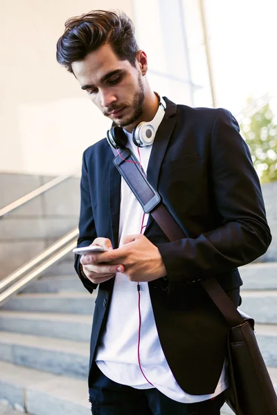 Jovem bonito usando seu telefone celular na rua . — Fotografia de Stock