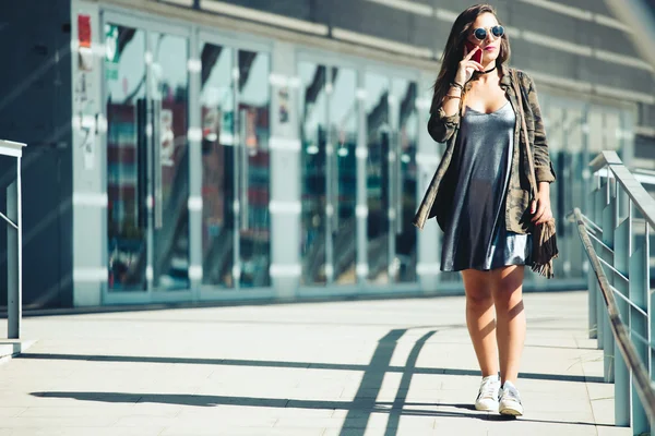 Mooie jonge vrouw met behulp van haar mobiele telefoon in de straat. — Stockfoto