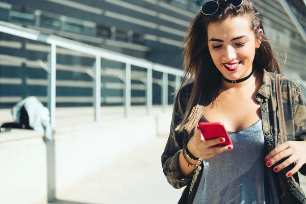 Красивая молодая женщина использует свой мобильный телефон на улице . — стоковое фото