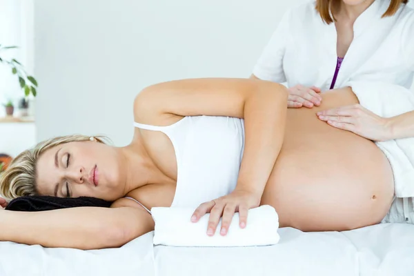 Красивая беременная женщина с массажем в спа . — стоковое фото