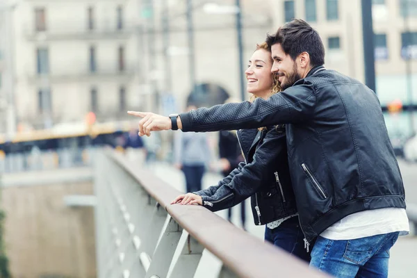 Sonriente pareja joven señalando algo en un día de otoño . — Foto de Stock