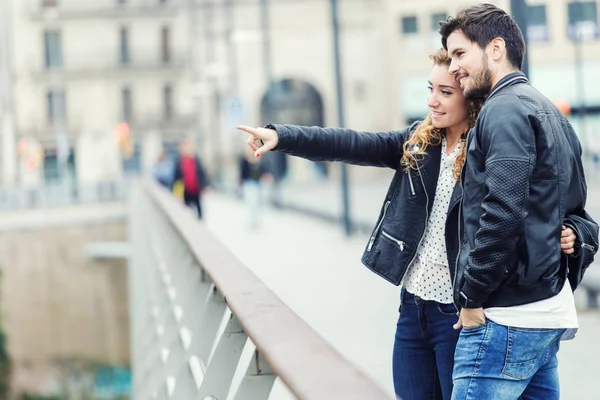 Sorrindo jovem casal apontando algo em um dia de outono . — Fotografia de Stock