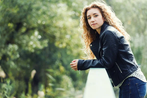 Mooie jonge vrouw kijken camera in het park. — Stockfoto