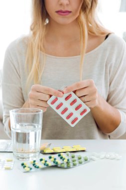 Depresif genç kadın evde hapları.