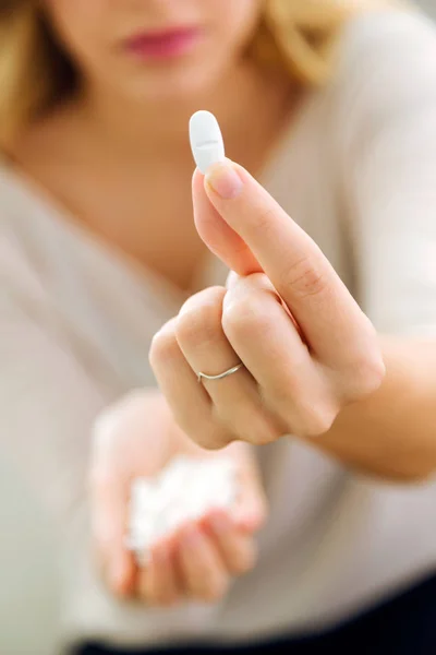 Депресивна молода жінка приймає таблетки вдома . — стокове фото
