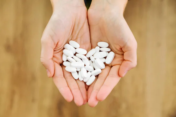 Båda händerna håller massa piller. Överdosering eller missbruk koncept. — Stockfoto