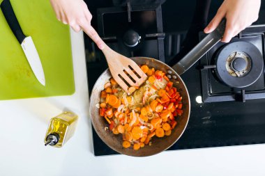 Genç kadın tava içine sebze kızartma.