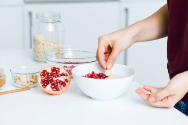 Genç kadın tahıl hazırlama mutfakta kaseler.