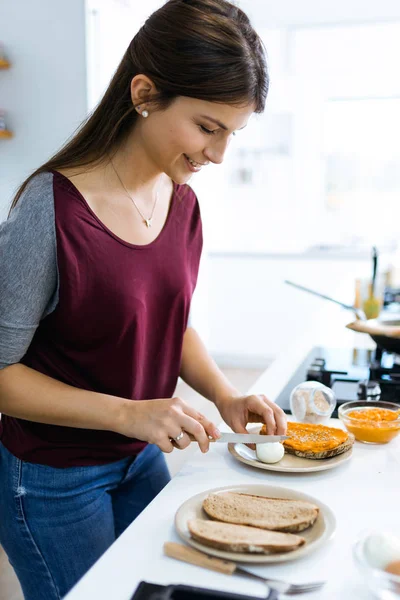 Mulher bonita preparando torrada com purê de legumes e ovo cozido . — Fotografia de Stock