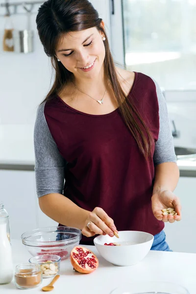 Mulher bonita preparando tigelas de cereais na cozinha . — Fotografia de Stock