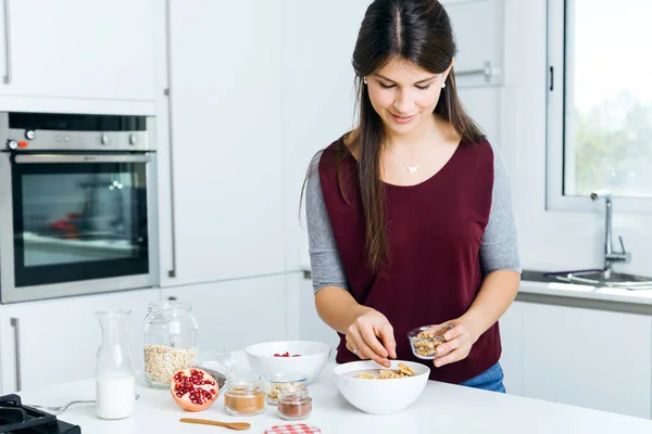 시리얼을 준비 하는 아름 다운 젊은 여자는 부엌에서 그릇. — 스톡 사진