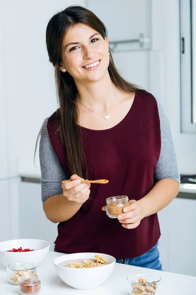 Mulher bonita preparando tigelas de cereais na cozinha . — Fotografia de Stock