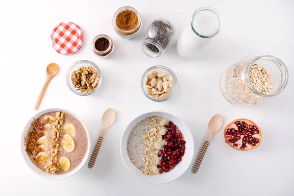 Ontbijt met melk en haver, noten, amandelen, banaan en granaatappel. — Stockfoto