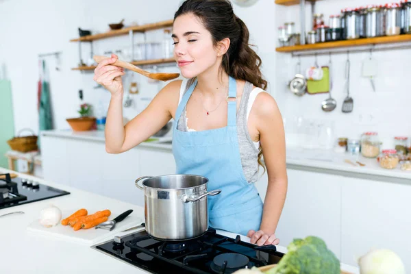 집에서 야채 스프를 요리 하는 아름 다운 젊은 여자. — 스톡 사진