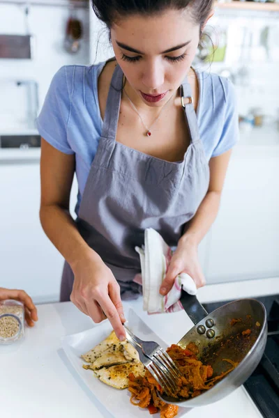 Mooie jonge vrouw serveren gebakken groenten in de plaat. — Stockfoto