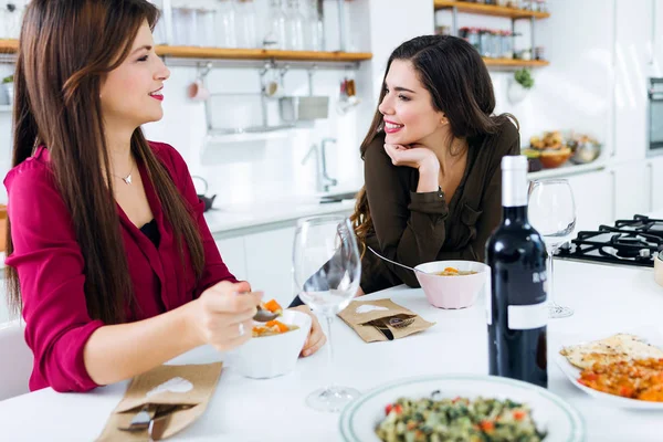 Две красивые молодые женщины едят овощной суп на кухне . — стоковое фото