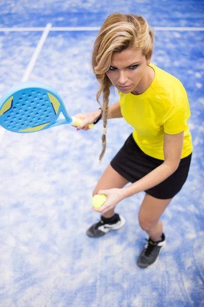 Mooie jonge vrouw met paddle tennis binnen. — Stockfoto