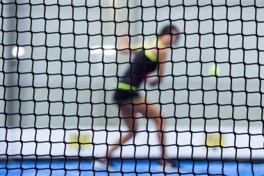 Güzel genç kadın kapalı raket tenis oynamaya.