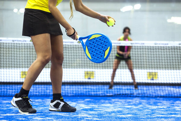 Two young women playing paddle tennis.
