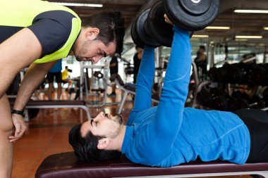 İki yakışıklı genç erkekler içinde jimnastik salonu kas egzersiz yapıyor.