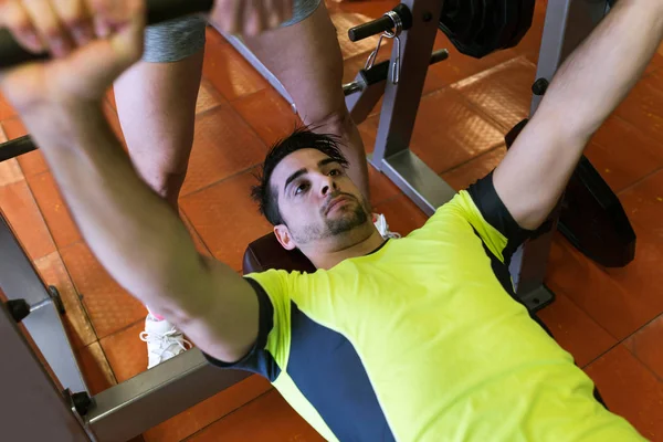 Beau jeune homme faisant de l'exercice musculaire dans la salle de gym . — Photo