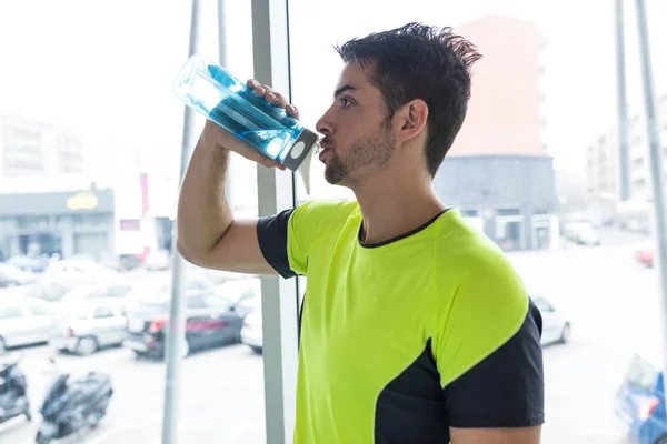 Handsome young sporty man relaxing after class in gym. — Stock Photo, Image