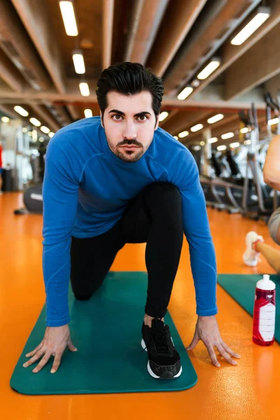 Joven guapo haciendo ejercicio muscular en el gimnasio . — Foto de Stock