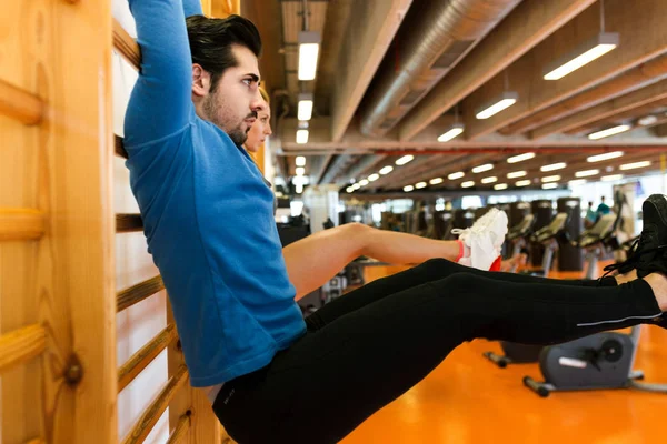 运动对年轻的夫妇做伸展在健身房. — 图库照片