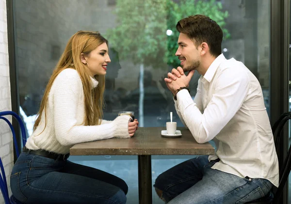 Hermosa pareja joven enamorada en una cafetería . — Foto de Stock